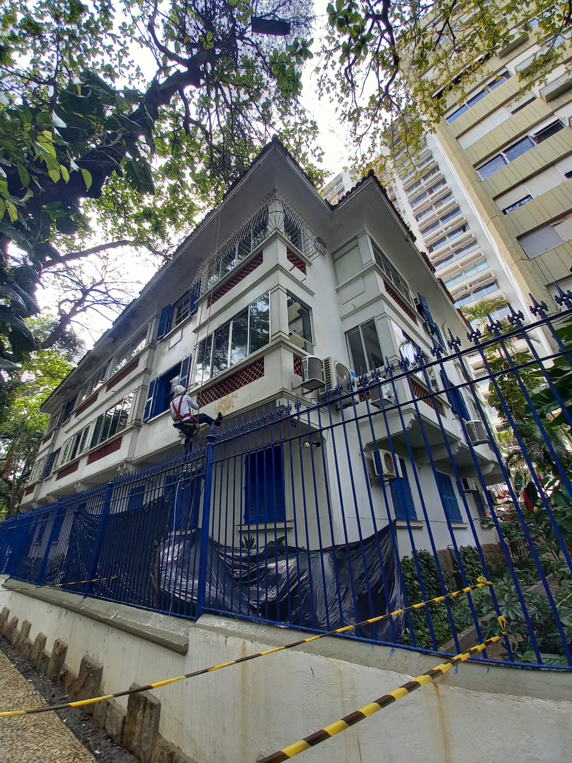 Equipe em acesso por corda durante obra de fachada predial no Condomínio Camucim, Leblon