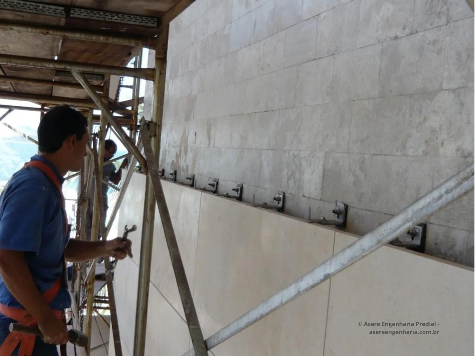 Linha de cantoneiras metálicas fixadas na parede, prontas para receber a fiada seguinte de placas.